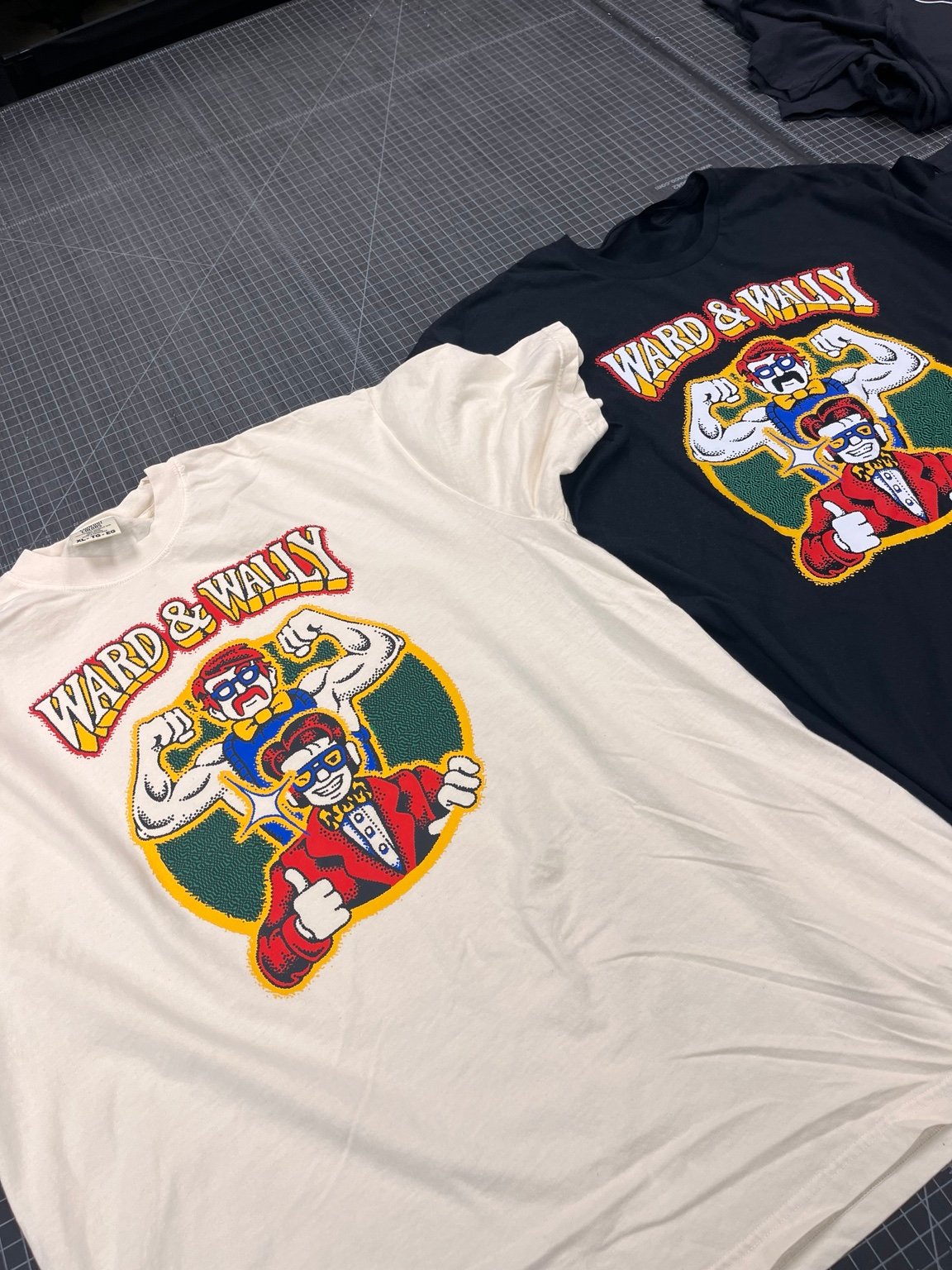 Custom printed Ward & Wally shirts laid out on a work table